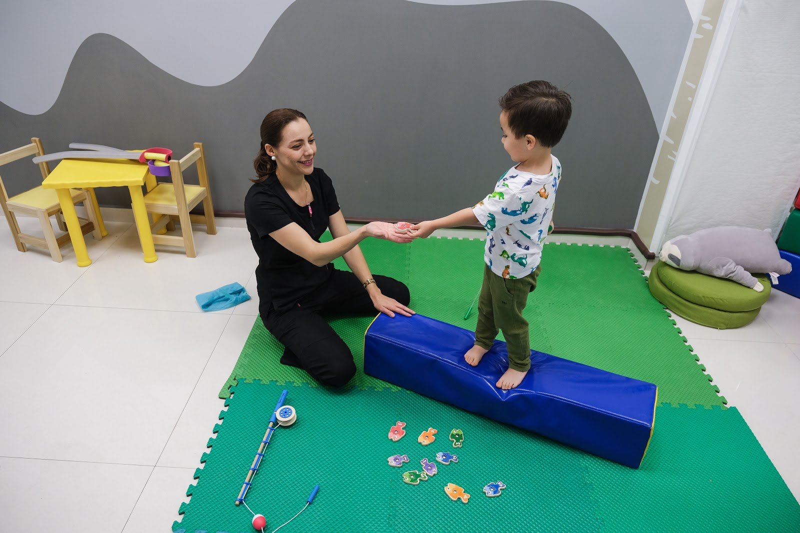 Terapeuta pediátrica acompañando a un niño en una sesión